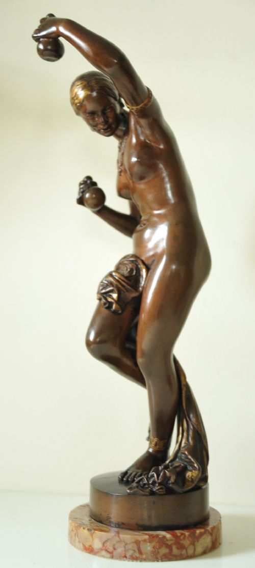 fig 1. A patinated dark bronze sculpture depicting a nude female dancer with gilded headpiece and drapery, raised on a rounded marble base.