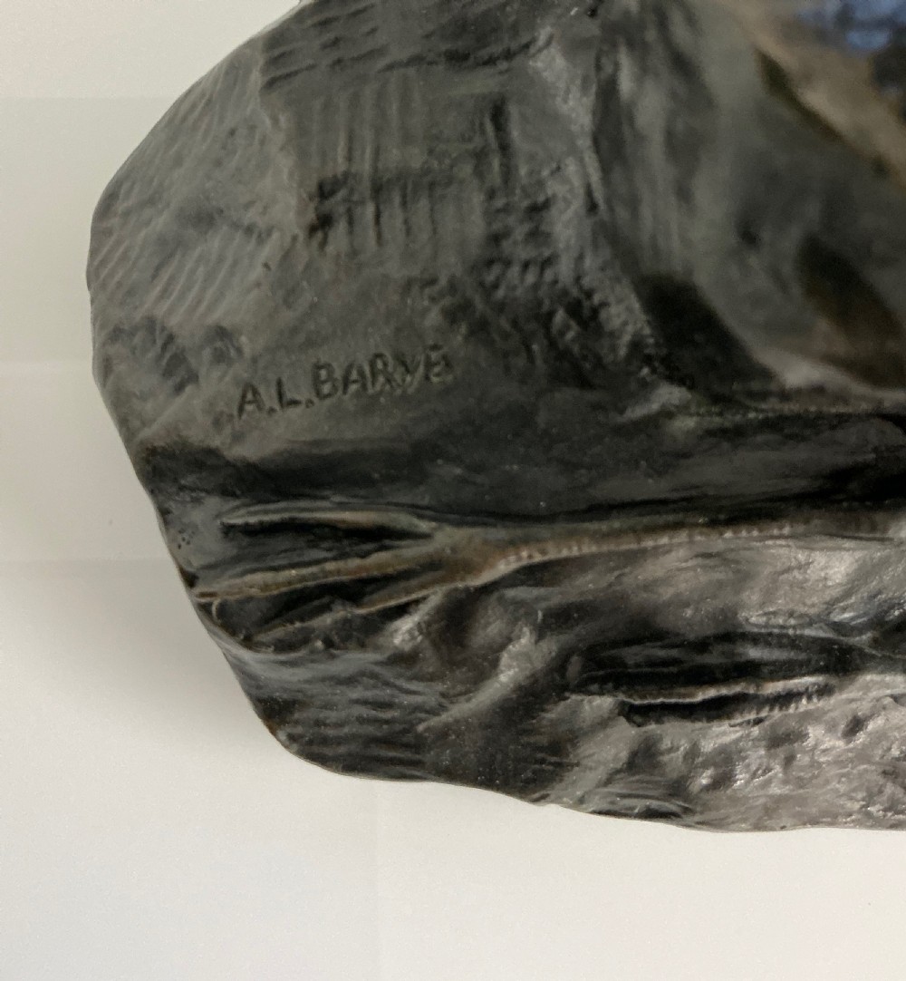 A dark patinated bronze sculpture depicting an eagle with outstretched wings perched on a rocky base above a second bird. View VI