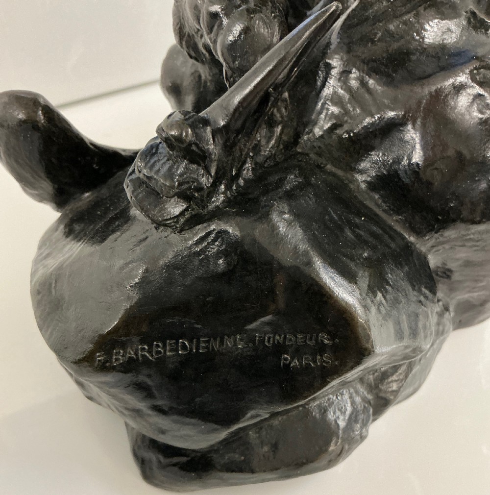 A dark patinated bronze sculpture depicting an eagle with outstretched wings perched on a rocky base above a second bird. View VII