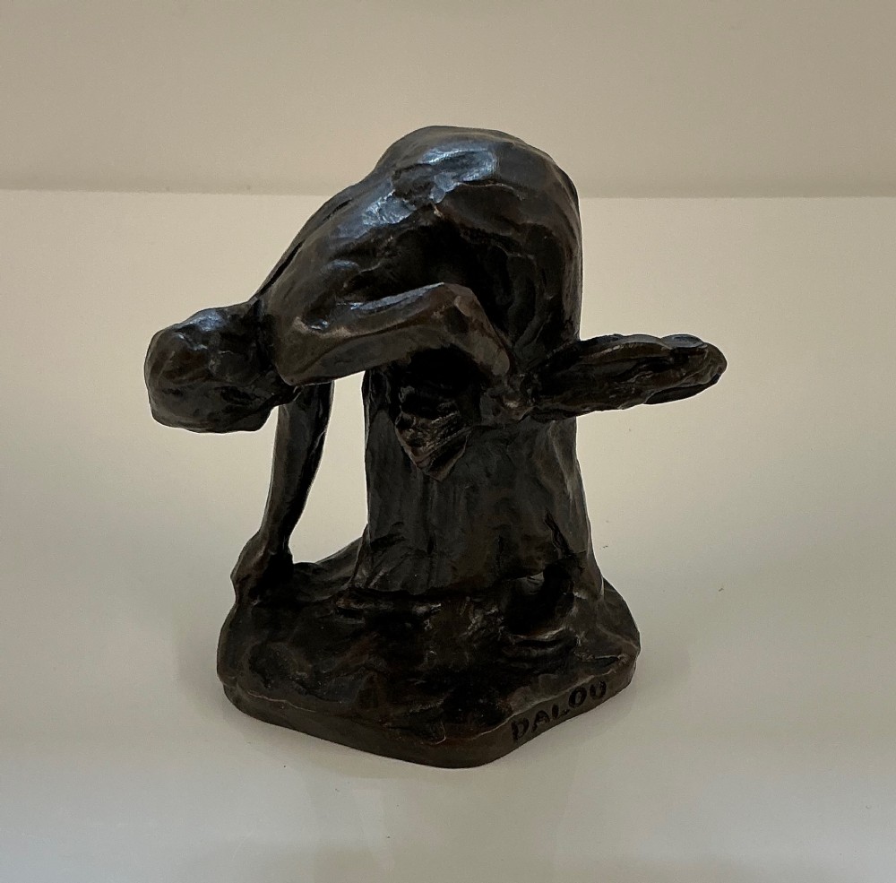 A dark brown patinated bronze sculpture of a bent female gleaner, mounted on an integral base with the incised signature Dalou.
