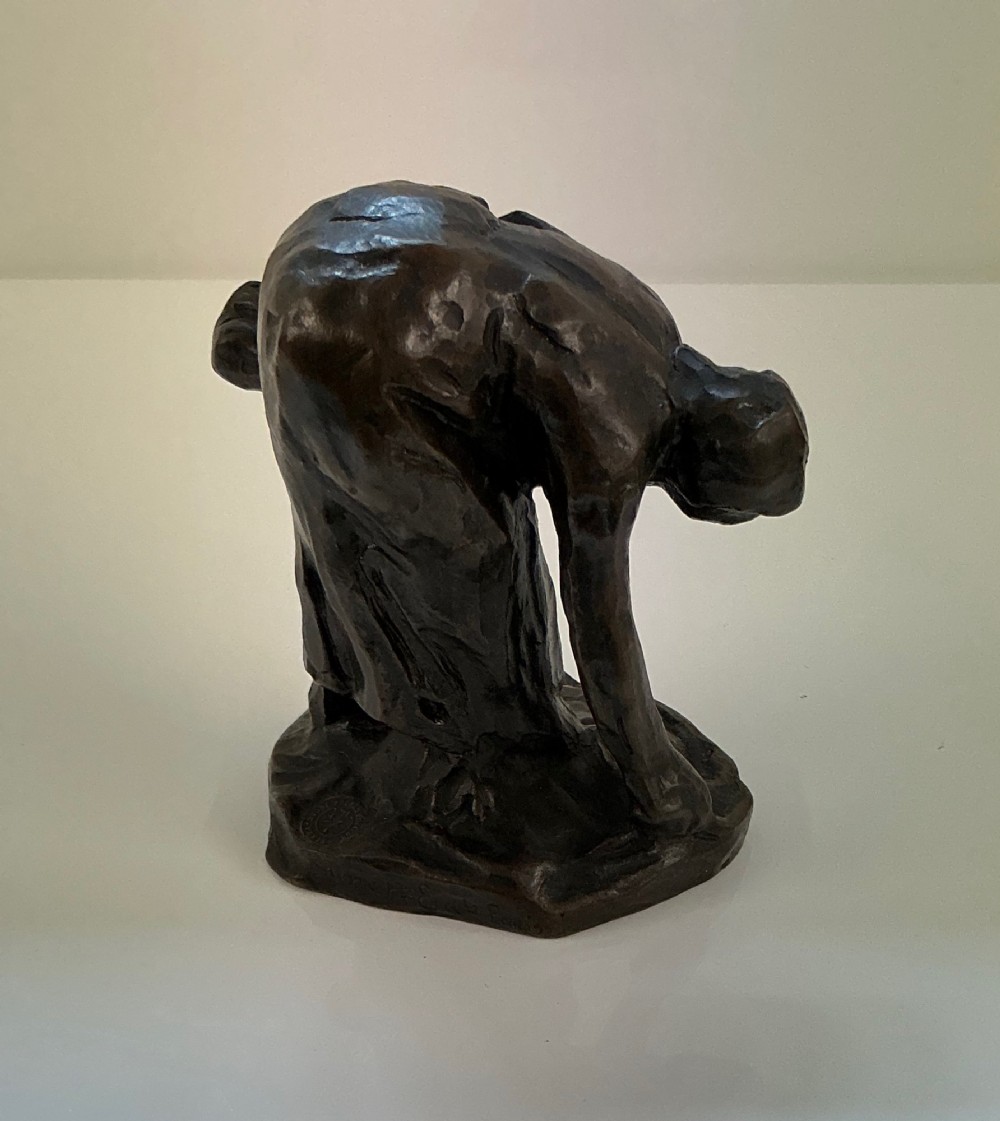 A dark brown patinated bronze sculpture of a bent female gleaner, mounted on an integral base with the incised signature Dalou. View II