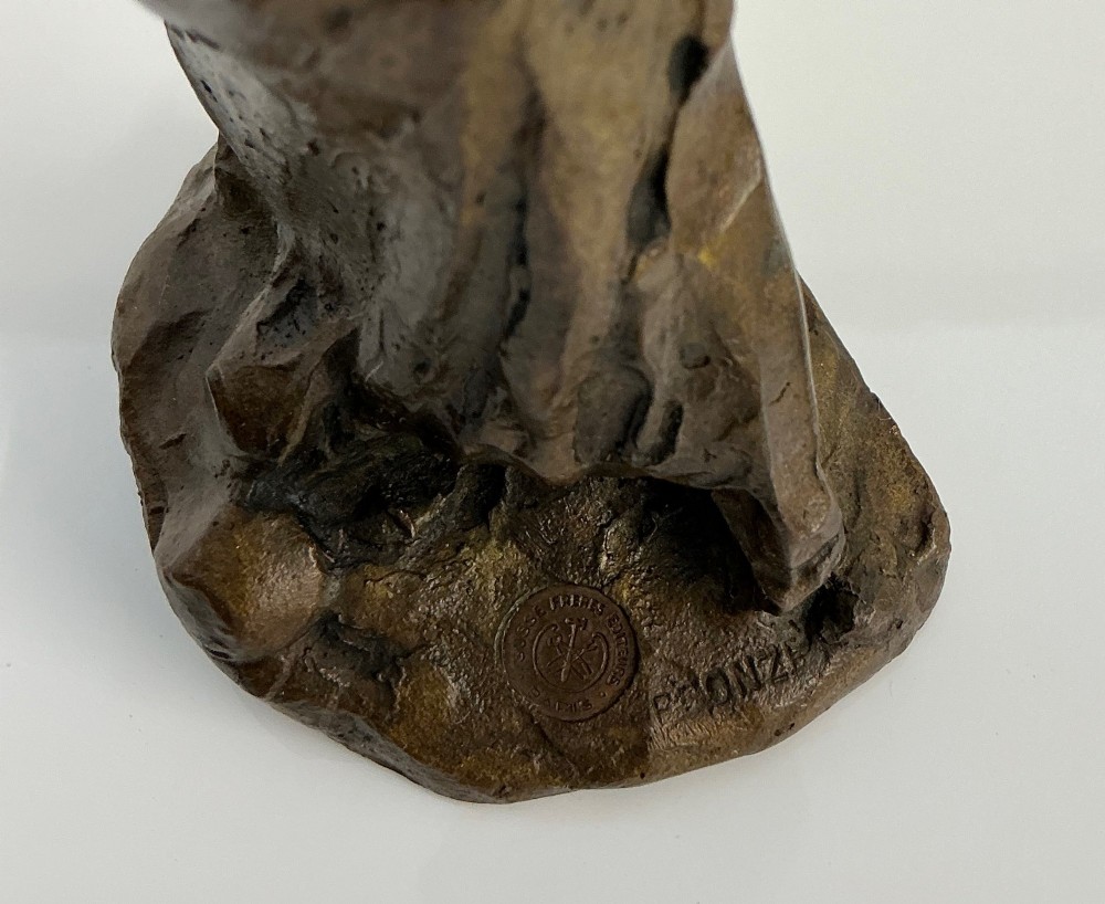 A patinated dark brown bronze sculpture by Jules Dalou depicting a bent female peasant figure carrying a heavy bundle. View III