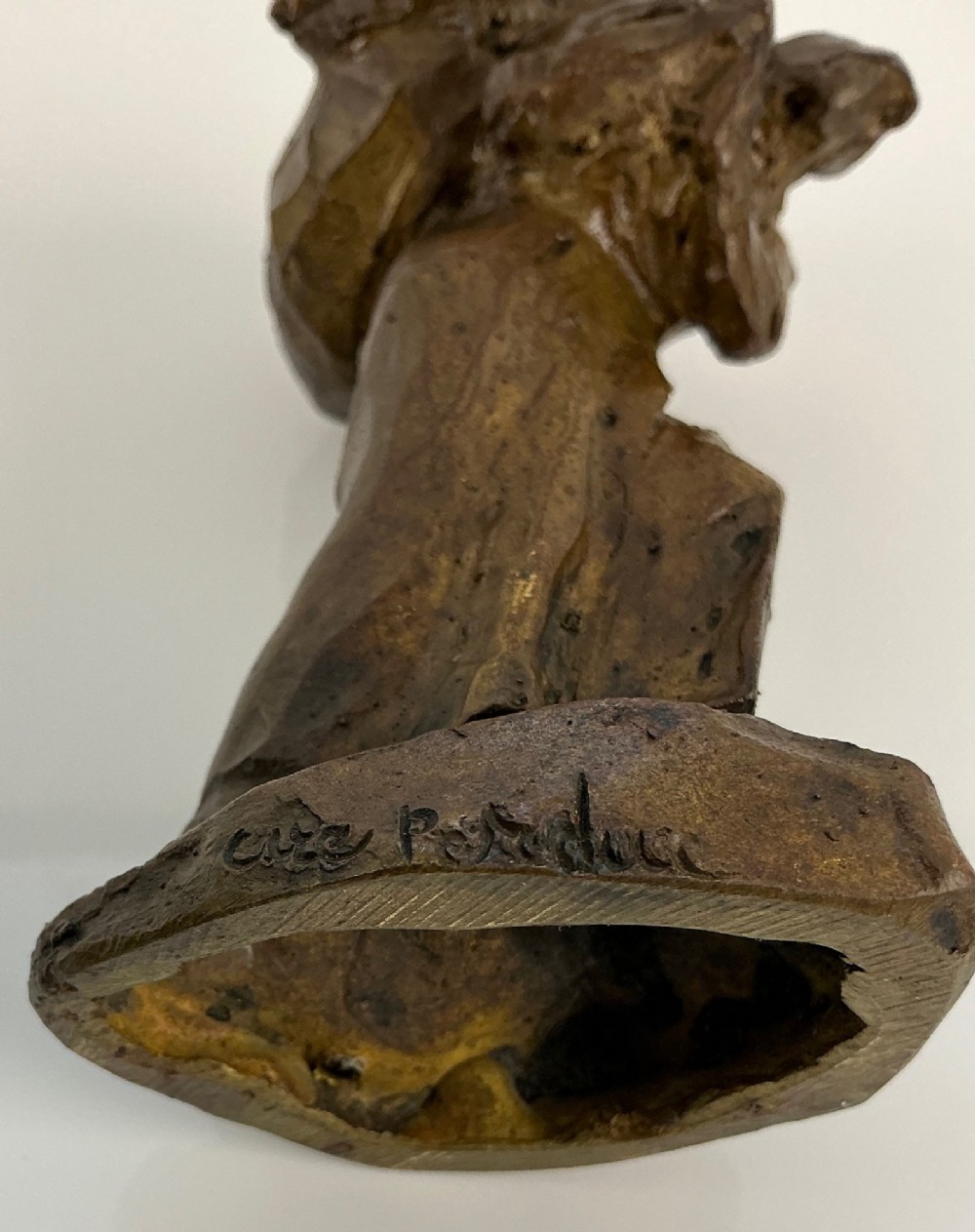 A patinated dark brown bronze sculpture by Jules Dalou depicting a bent female peasant figure carrying a heavy bundle. View IV