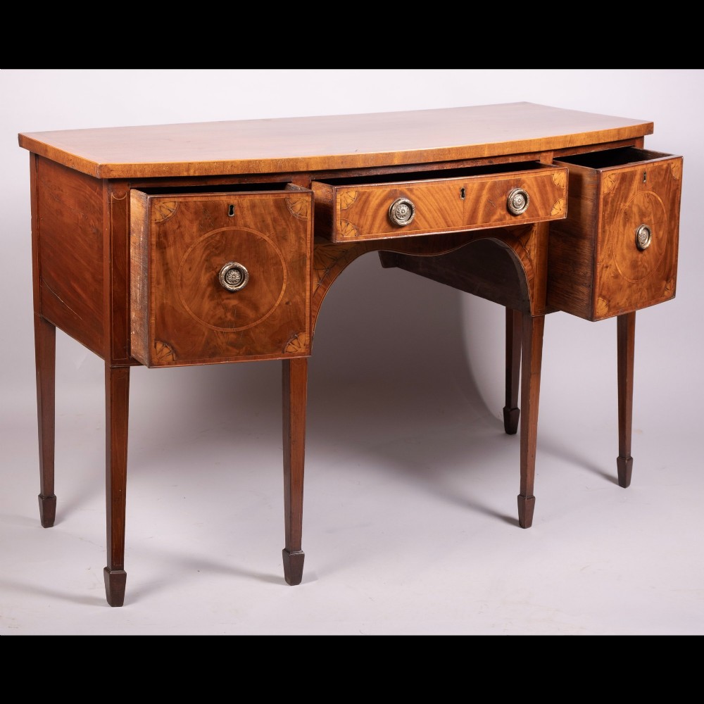 An 18th-century Georgian mahogany bow-fronted sideboard with satinwood inlays, central drawer, two flanking doors, and tapered square legs. View III