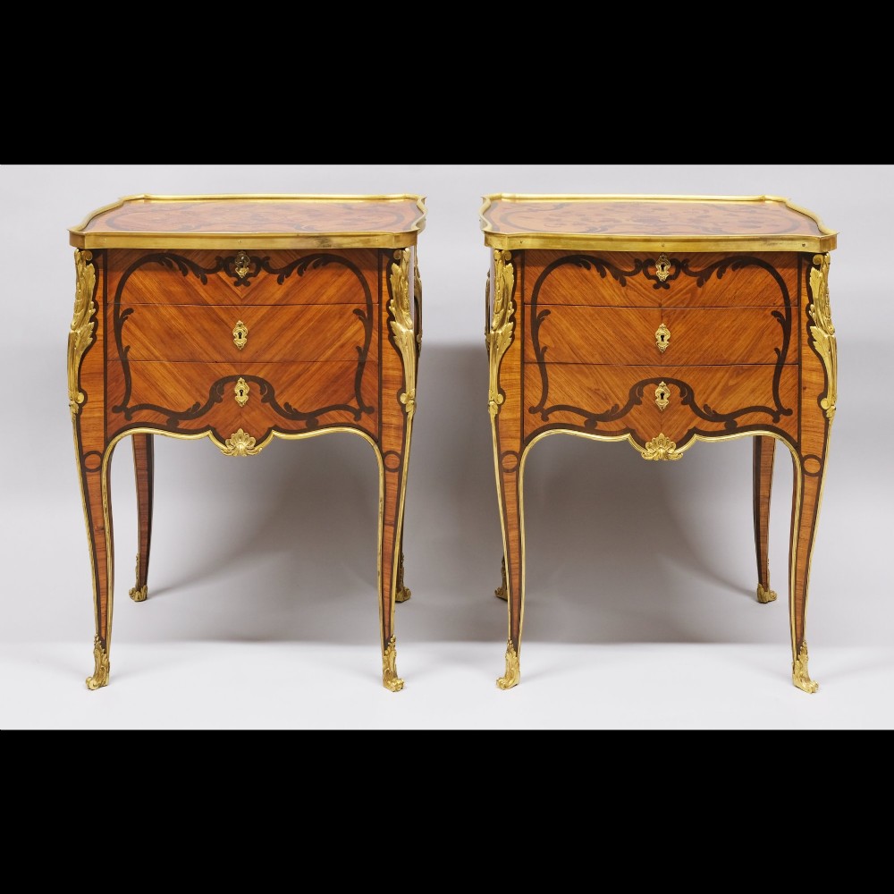 A pair of French Louis XV style inlaid timber commodes featuring serpentine fronts, marquetry veneering, cabriole legs, and chased gilt-bronze mounts. View III