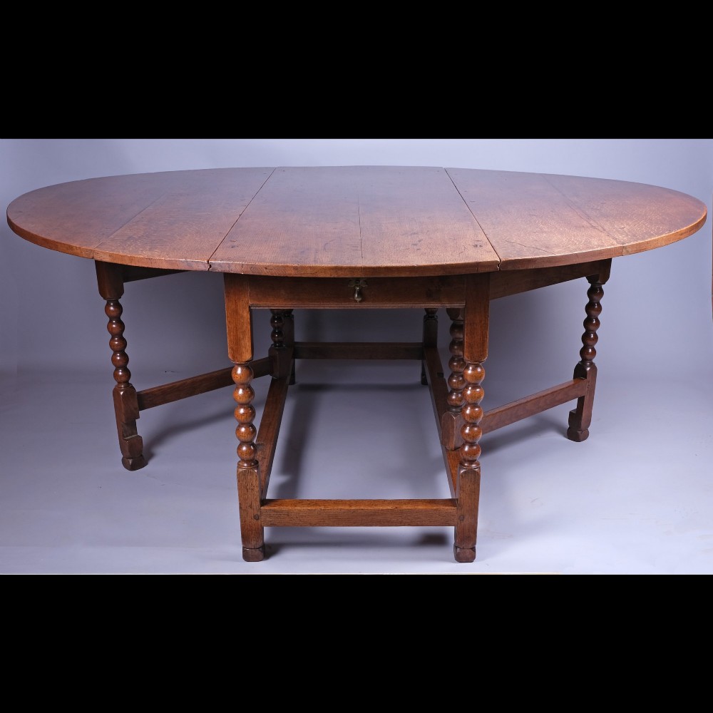 A 17th-century oak gateleg table featuring two drop leaves, bobbin-turned legs, and lower perimeter stretchers. View III