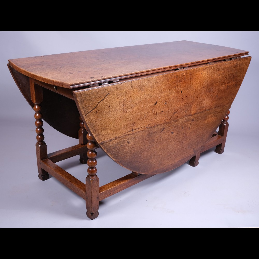 A 17th-century oak gateleg table featuring two drop leaves, bobbin-turned legs, and lower perimeter stretchers. View IV