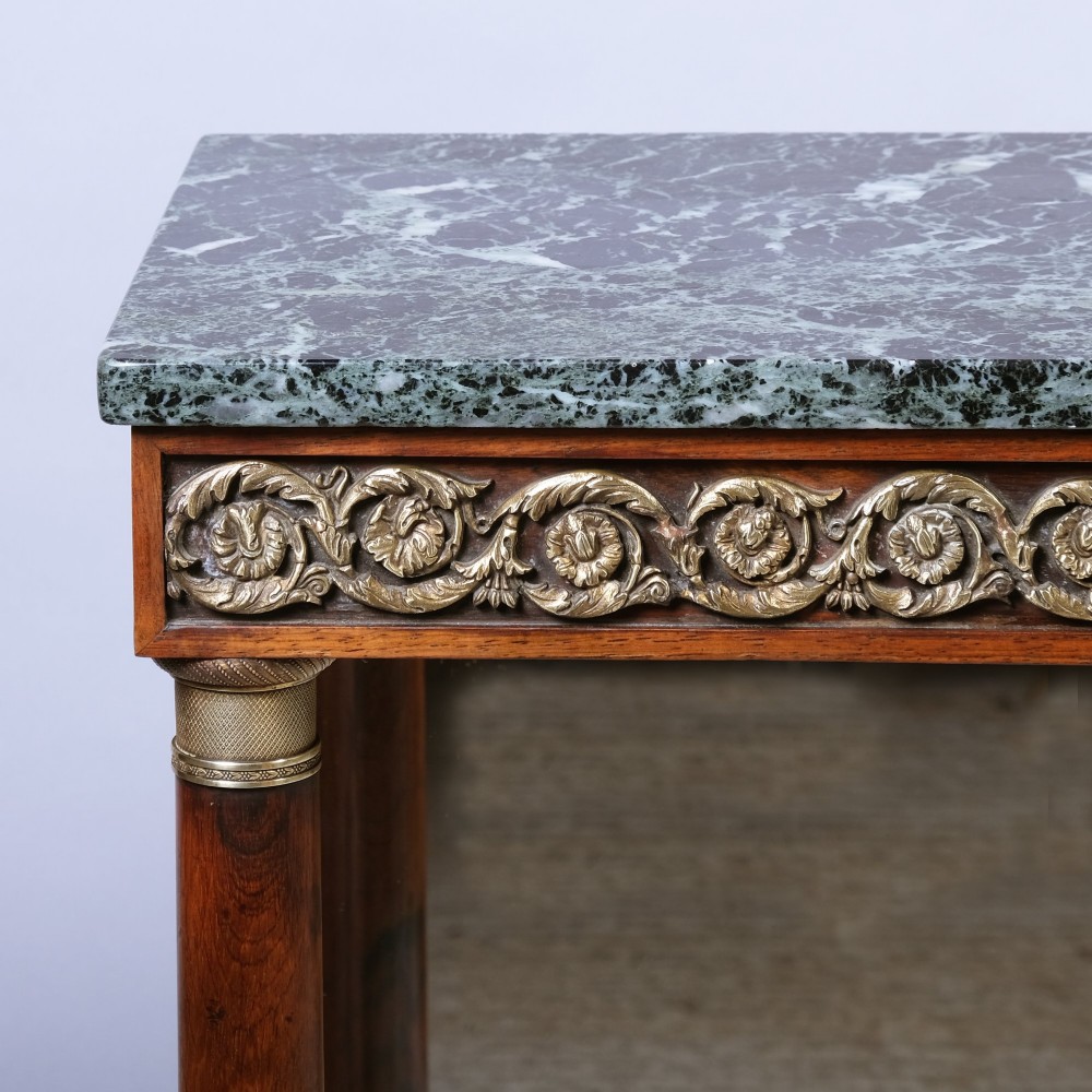 An antique First Empire rosewood console table featuring a dark green marble top, gilt brass mounts along the frieze, cylindrical column supports, and a lower shelf. View III