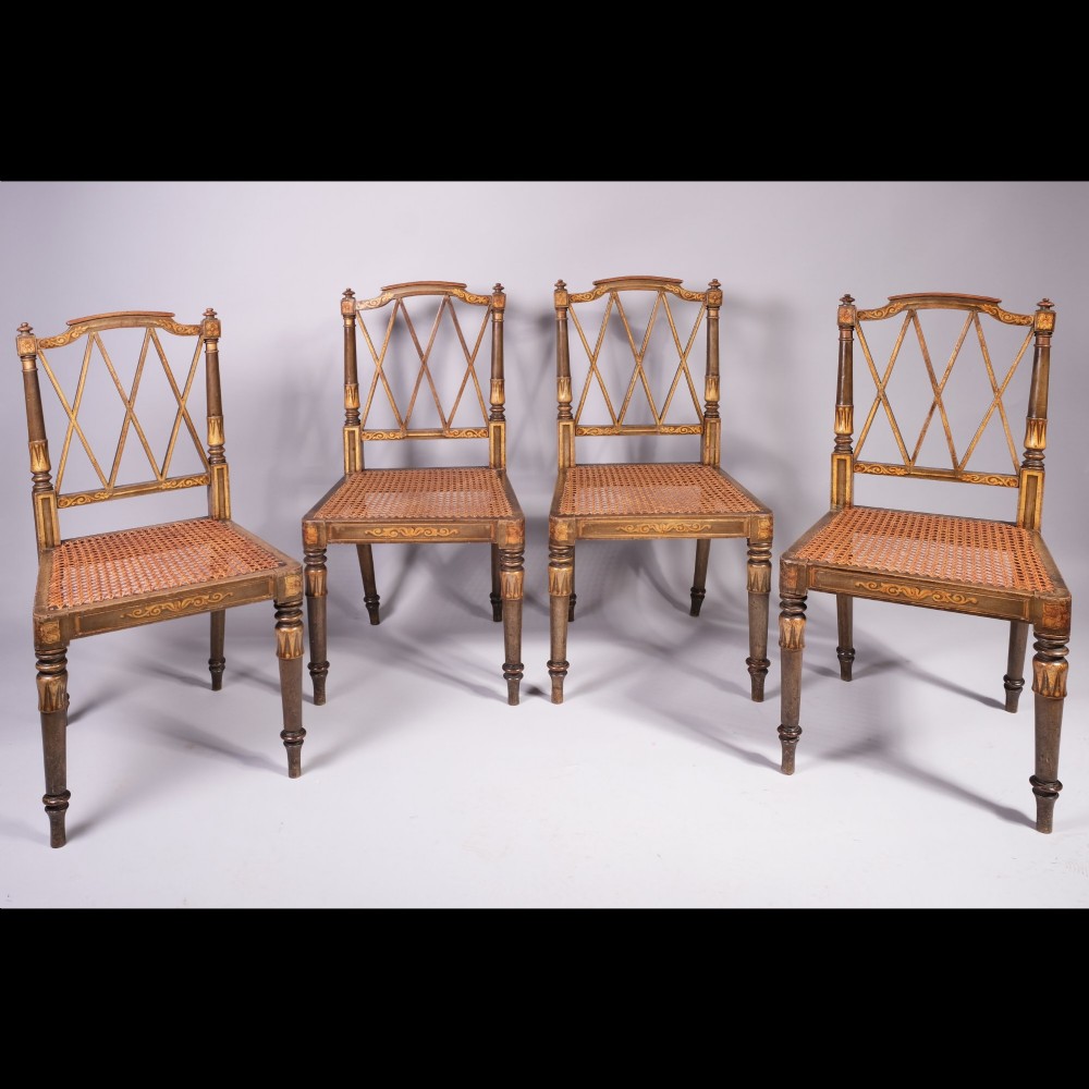 A set of four early nineteenth-century Regency side chairs featuring diamond-lattice backrests, turned front legs, woven cane seats, and gold painted decorative borders.