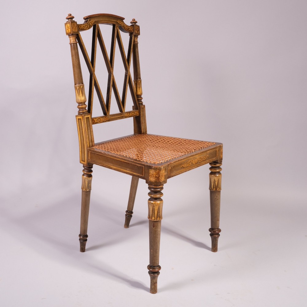 A set of four early nineteenth-century Regency side chairs featuring diamond-lattice backrests, turned front legs, woven cane seats, and gold painted decorative borders. View II