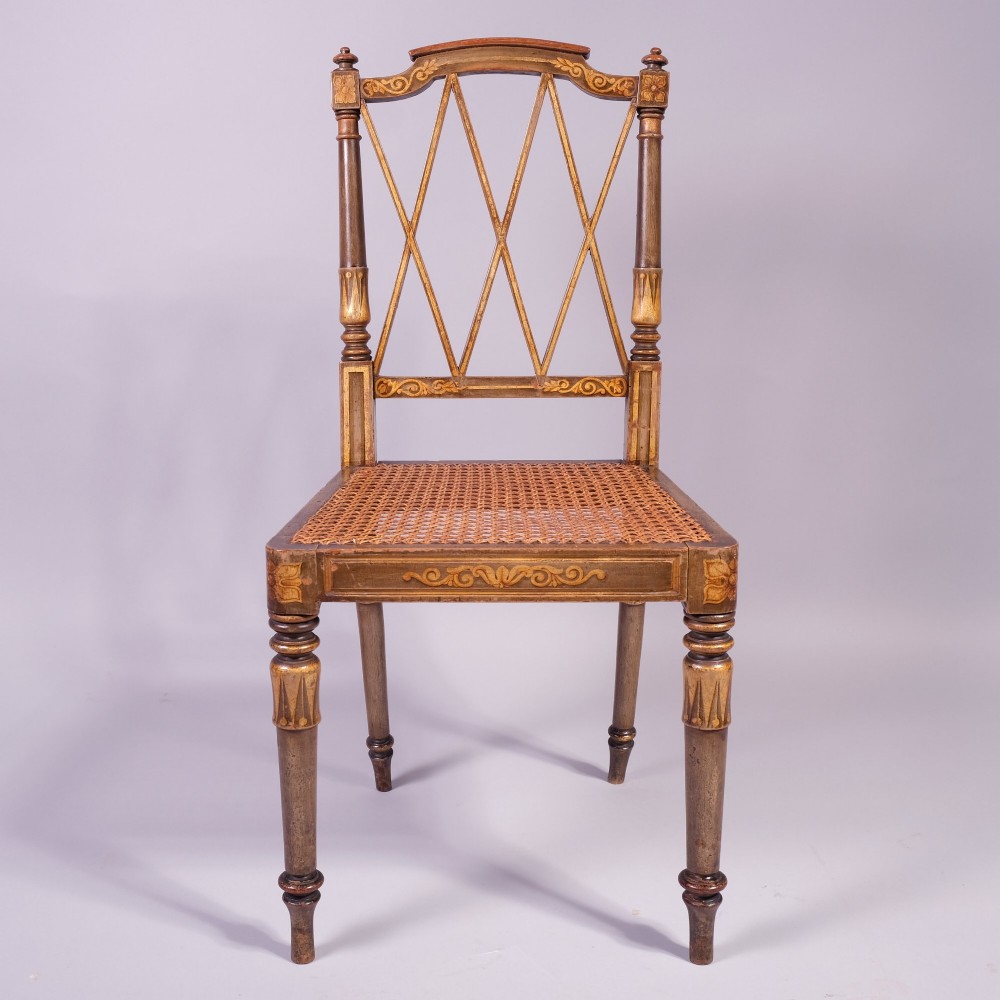 A set of four early nineteenth-century Regency side chairs featuring diamond-lattice backrests, turned front legs, woven cane seats, and gold painted decorative borders. View III