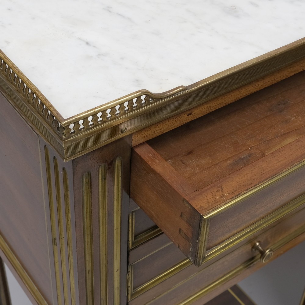 A pair of tall 19th century French Empire mahogany bedside cabinets featuring brass galleries, four drawers with brass mouldings, fluted legs, and lower shelves. View II
