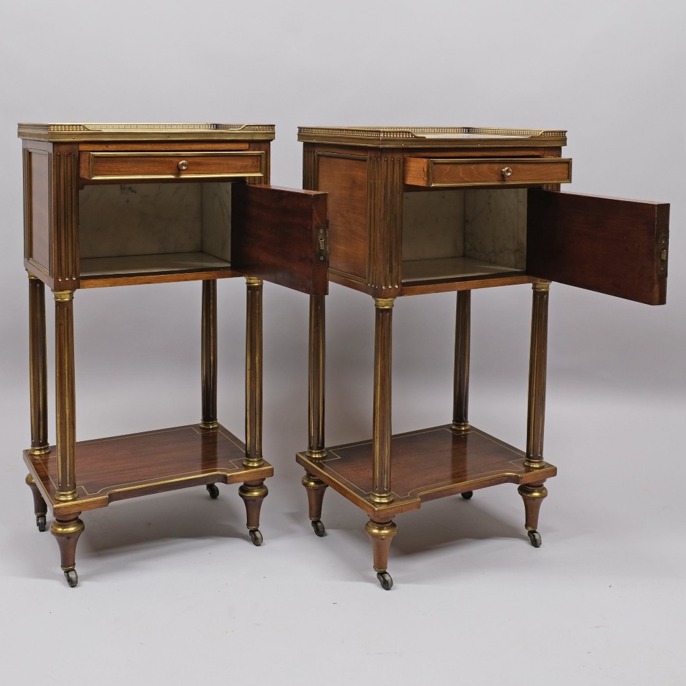 A pair of tall 19th century French Empire mahogany bedside cabinets featuring brass galleries, four drawers with brass mouldings, fluted legs, and lower shelves. View III