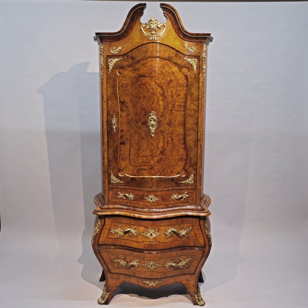 An antique 19th-century burr walnut cabinet on a bombe chest of drawers featuring ornate gilt-bronze mounts and an arched pediment top. View III