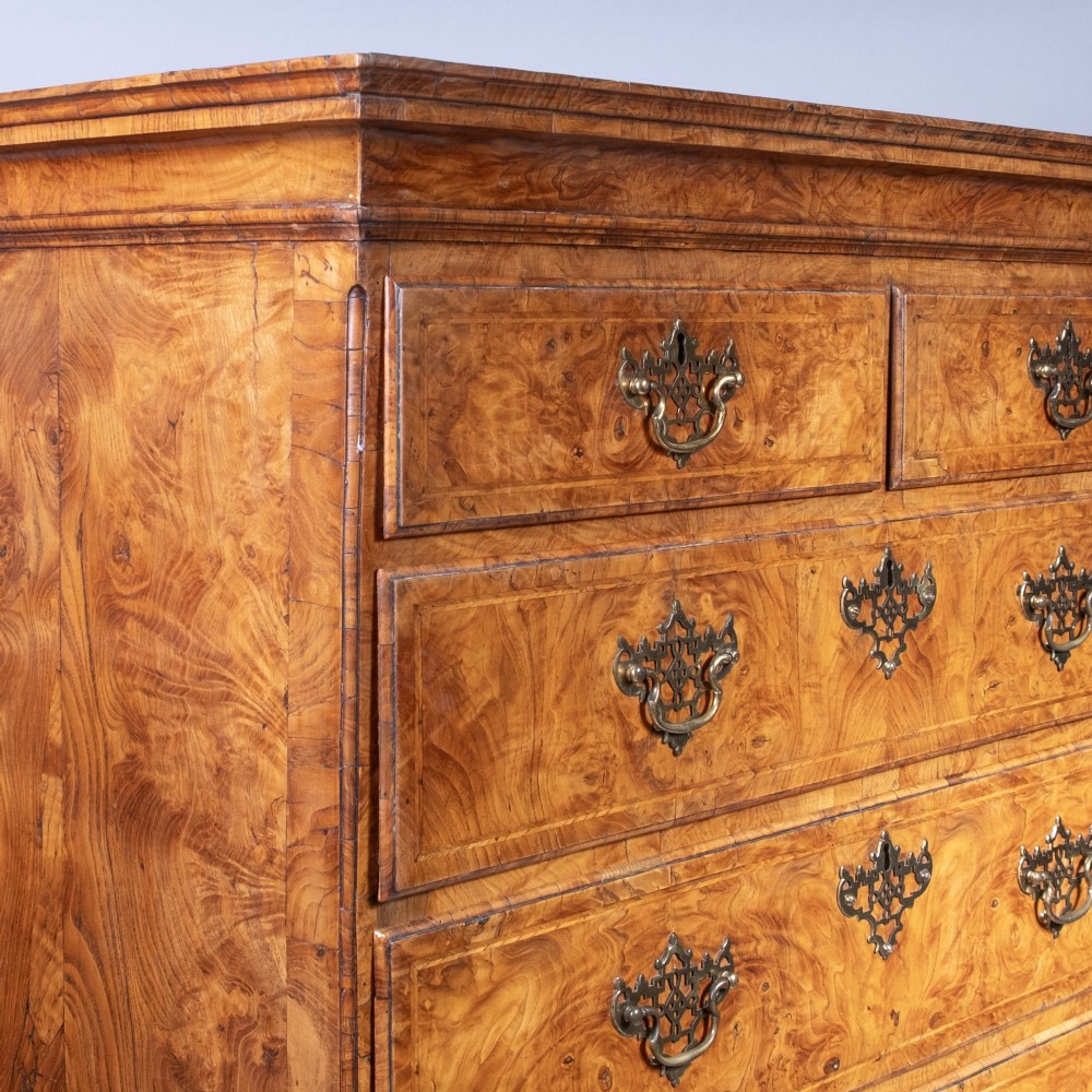 An early eighteenth-century George I elm tallboy chest-on-chest featuring two sections with multiple graduating drawers and decorative brass handles set on bracket feet. View II