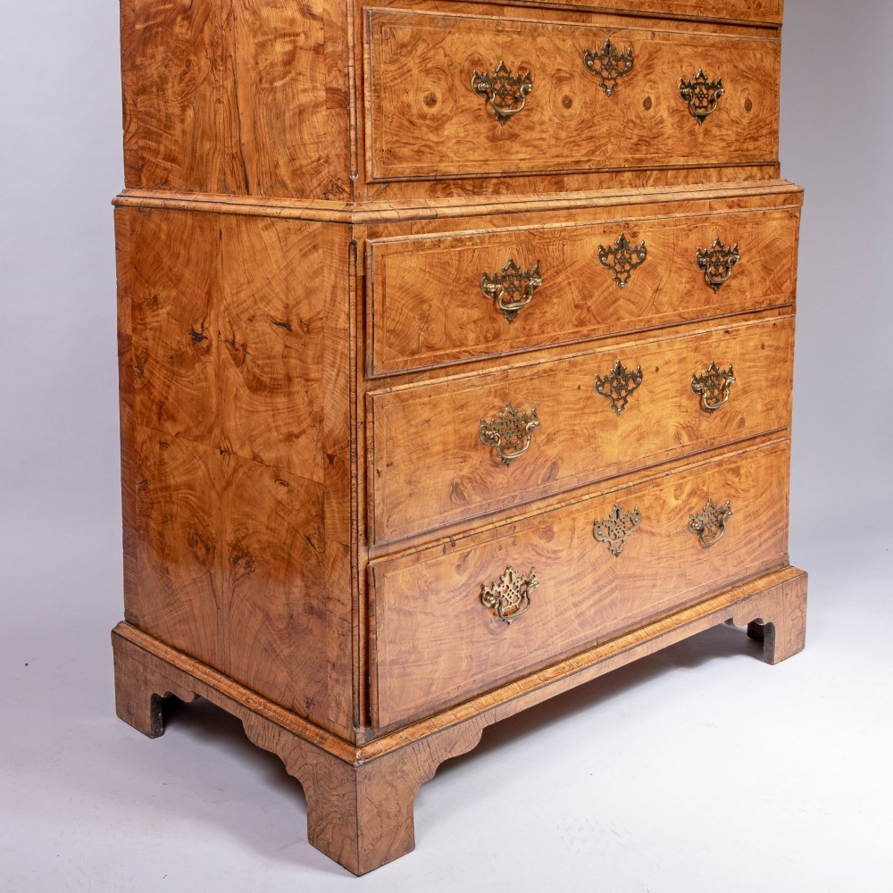 An early eighteenth-century George I elm tallboy chest-on-chest featuring two sections with multiple graduating drawers and decorative brass handles set on bracket feet. View III