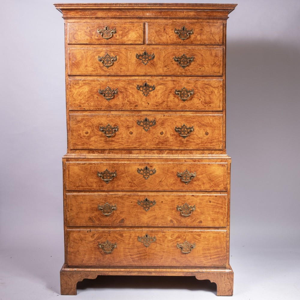 An early eighteenth-century George I elm tallboy chest-on-chest featuring two sections with multiple graduating drawers and decorative brass handles set on bracket feet. View IV