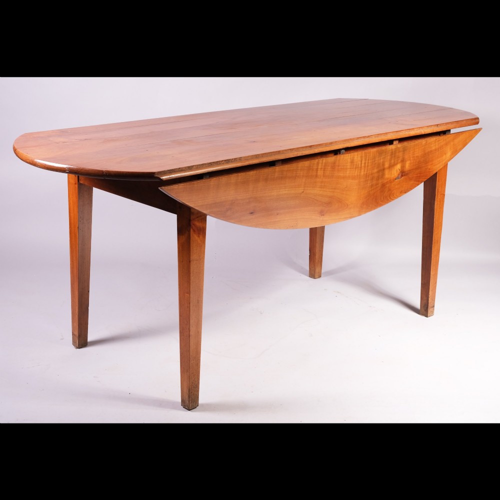 A nineteenth-century French oval dining table crafted from warm brown cherrywood with four tapered square legs. View III