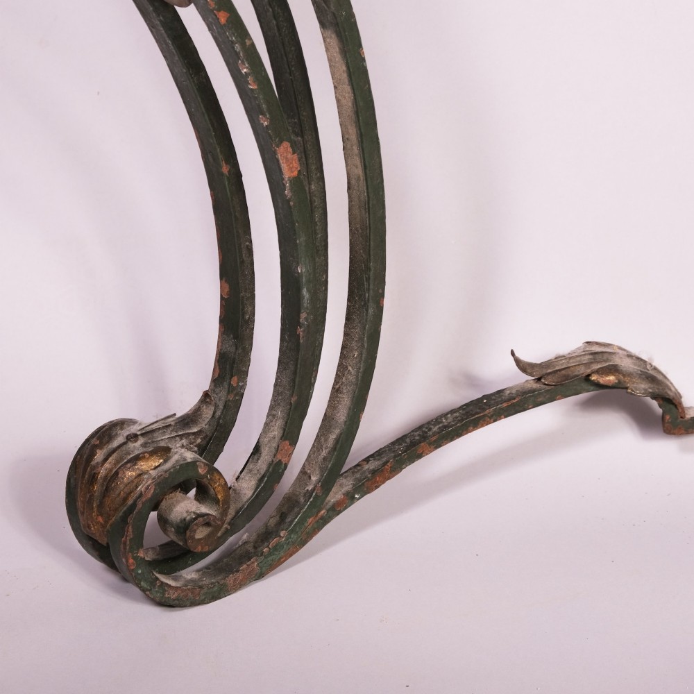 A 19th-century serpentine console table featuring a contoured marble top resting on a dark green wrought iron frame decorated with floral rosettes and scrollwork. View II