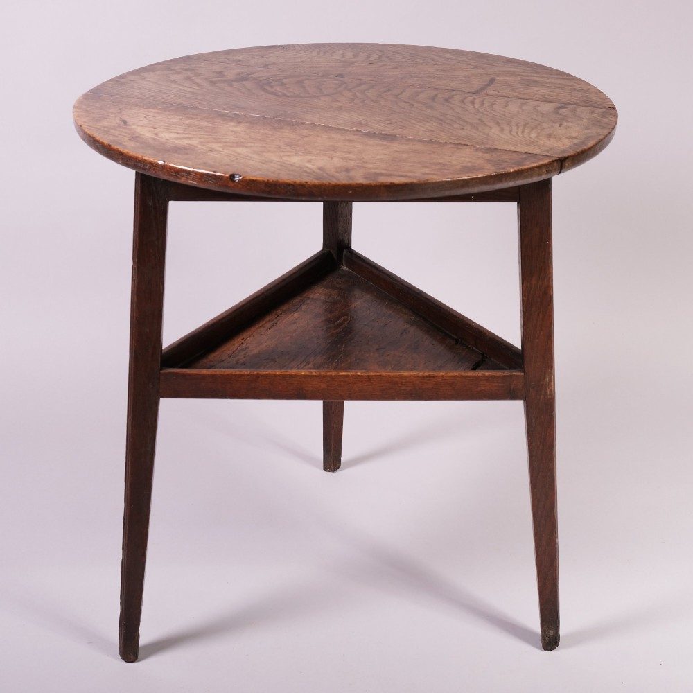 An 18th-century ash wood cricket table featuring a round top, three straight tapered legs, and a triangular lower shelf in a warm brown finish. View III