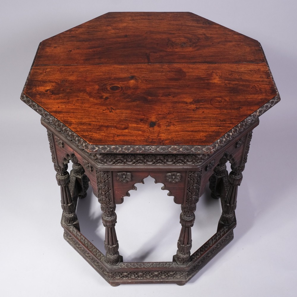 A 19th-century octagonal dark hardwood table featuring deeply carved floral borders, cusped arch aprons, turned multi-baluster legs, and a fitted base shelf. View II