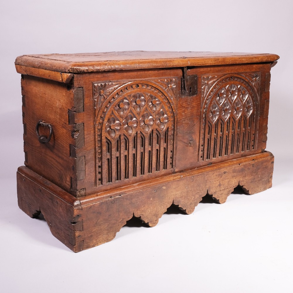 An antique oak and elm coffer featuring carved Gothic tracery arches across the front panel and a hand-forged iron lockplate. View II