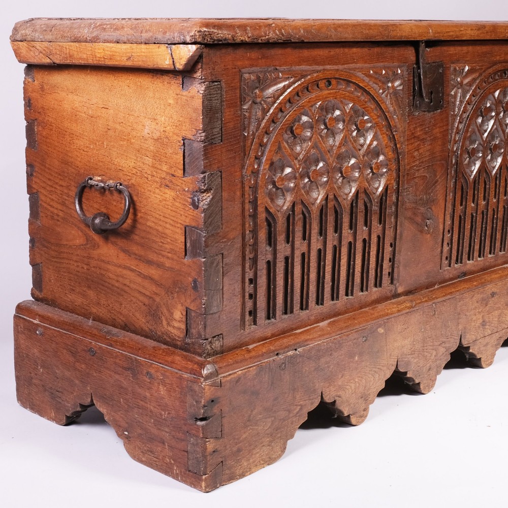 An antique oak and elm coffer featuring carved Gothic tracery arches across the front panel and a hand-forged iron lockplate. View III