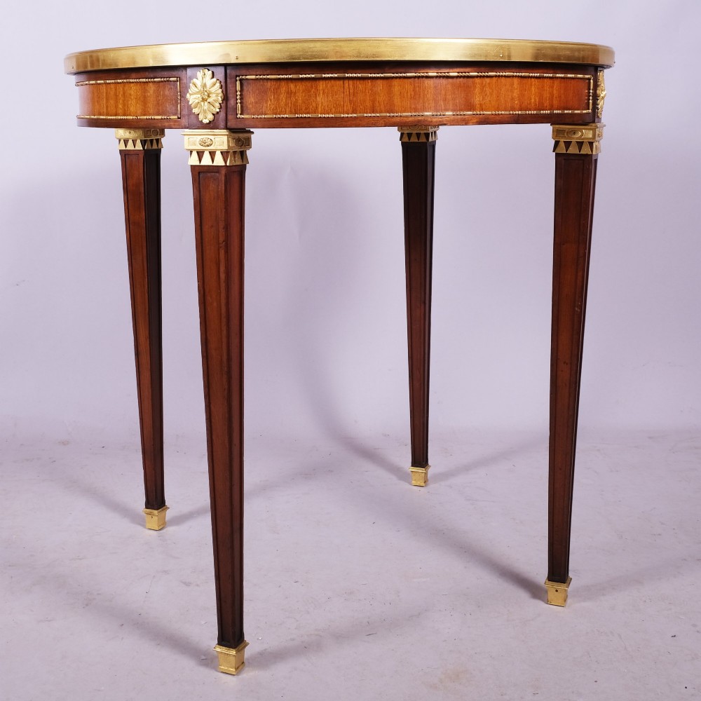 A late 19th-century French Louis XVI style circular bouillotte table featuring a marble top with brass gallery rim, mahogany frieze with gilt mounts, and four square tapered legs. View II