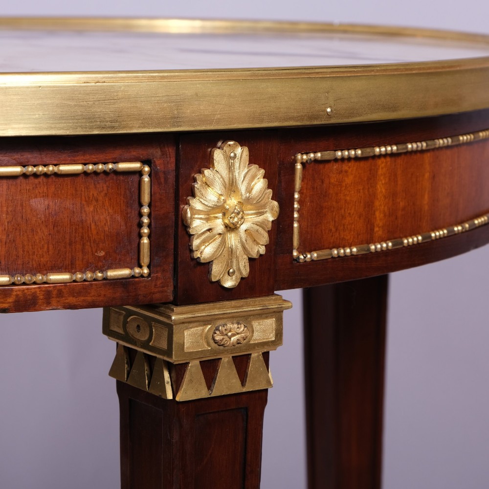 A late 19th-century French Louis XVI style circular bouillotte table featuring a marble top with brass gallery rim, mahogany frieze with gilt mounts, and four square tapered legs. View III