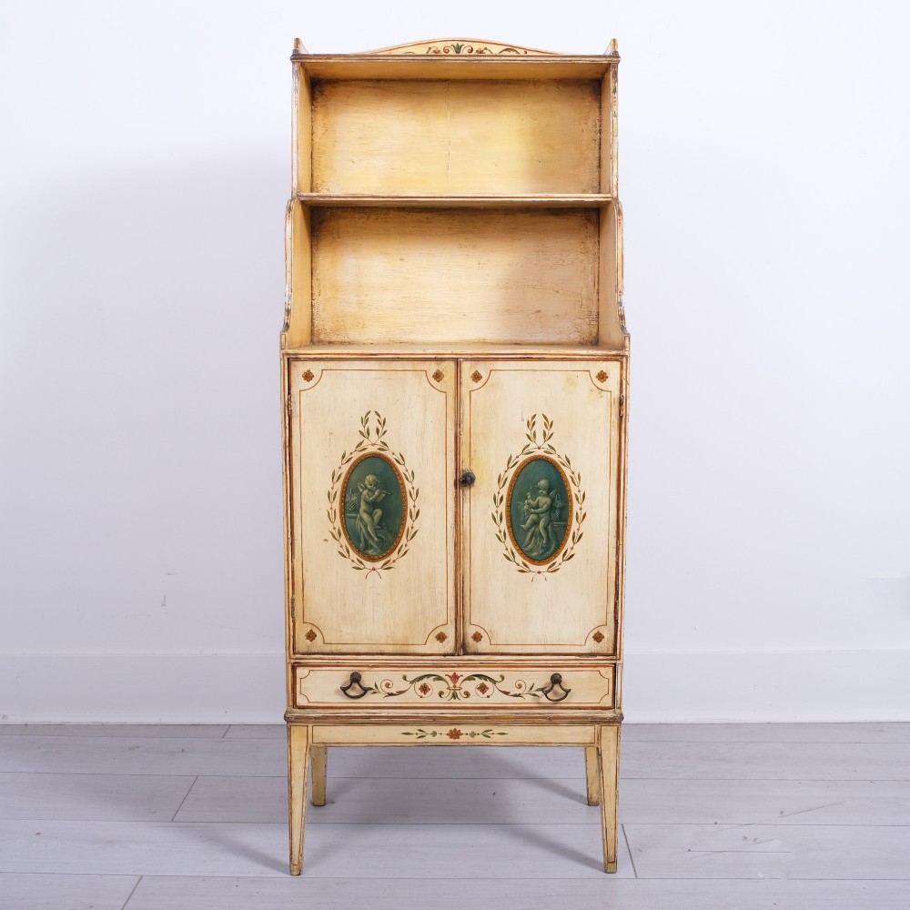 A late 18th-century George III painted waterfall bookcase featuring tiered open shelves above a two-door cabinet with green painted medallions and a single drawer on tapered legs. View IV