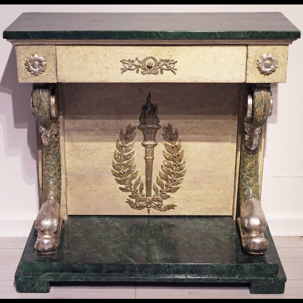 A late 18th-century Gustavian console table with a green marble top, cream painted finish, carved rosettes, scrolled legs, and a back panel featuring a carved torch with a laurel wreath motif.
