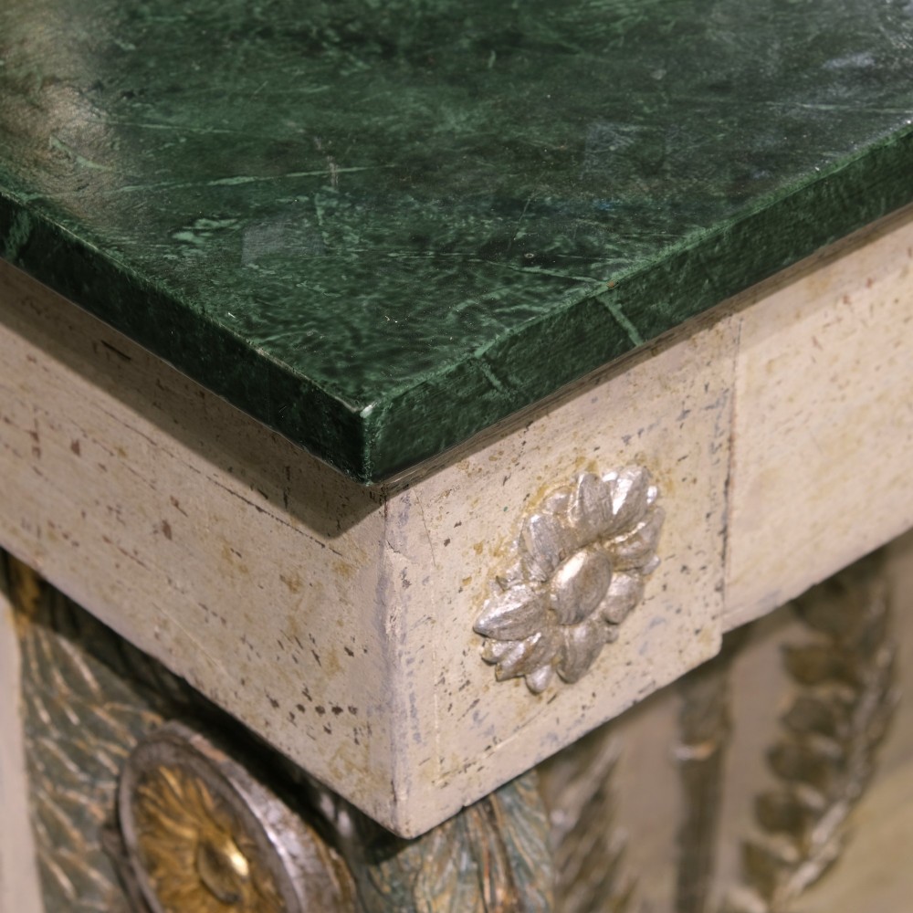 A late 18th-century Gustavian console table with a green marble top, cream painted finish, carved rosettes, scrolled legs, and a back panel featuring a carved torch with a laurel wreath motif. View II