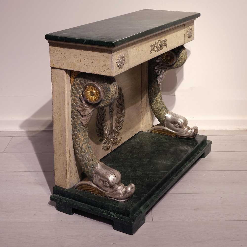 A late 18th-century Gustavian console table with a green marble top, cream painted finish, carved rosettes, scrolled legs, and a back panel featuring a carved torch with a laurel wreath motif. View IV
