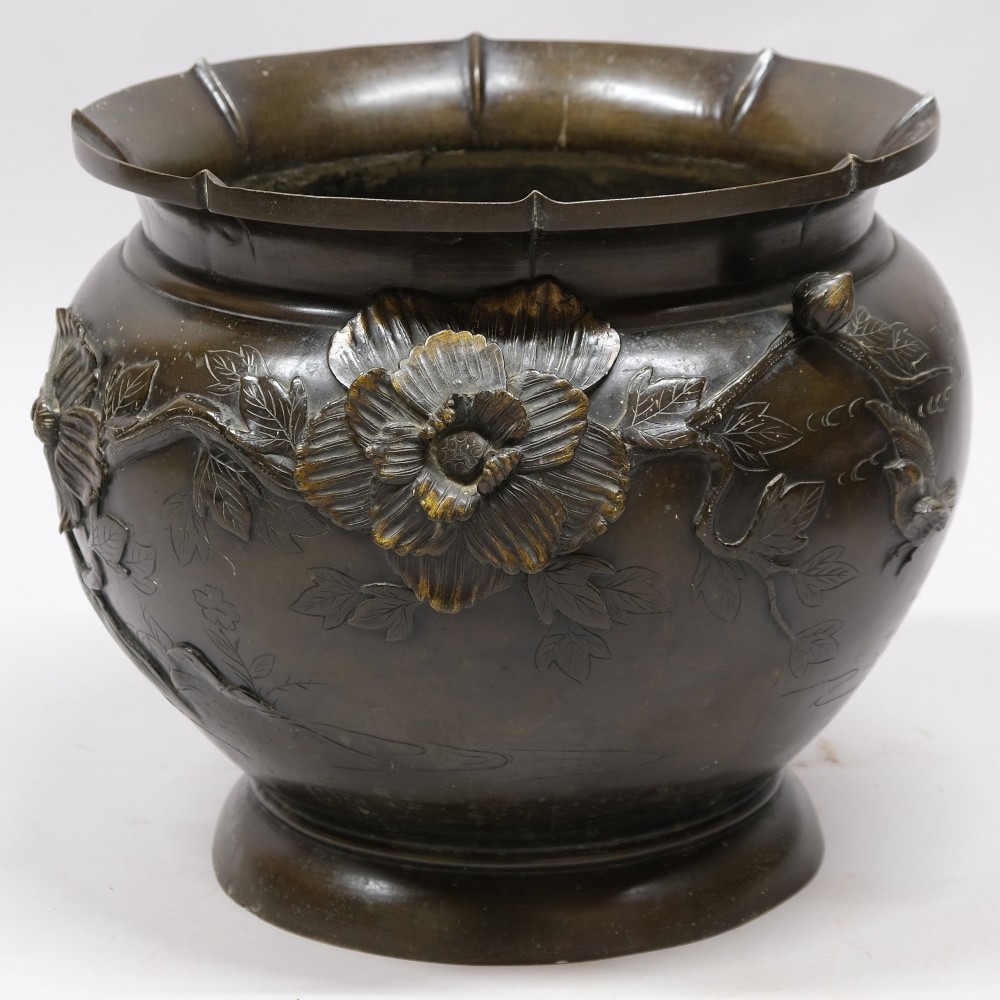 A dark bronze cast metal jardiniere featuring a scalloped rim, flared circular base, and raised floral relief decorations around the main body. View II