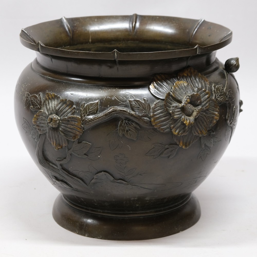 A dark bronze cast metal jardiniere featuring a scalloped rim, flared circular base, and raised floral relief decorations around the main body. View IV
