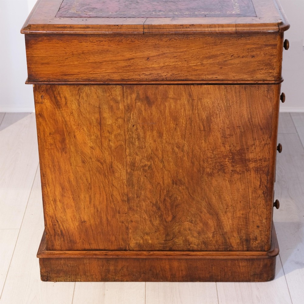 A Victorian burr walnut pedestal desk featuring nine drawers with turned wooden knobs and an inset leather writing surface. View II