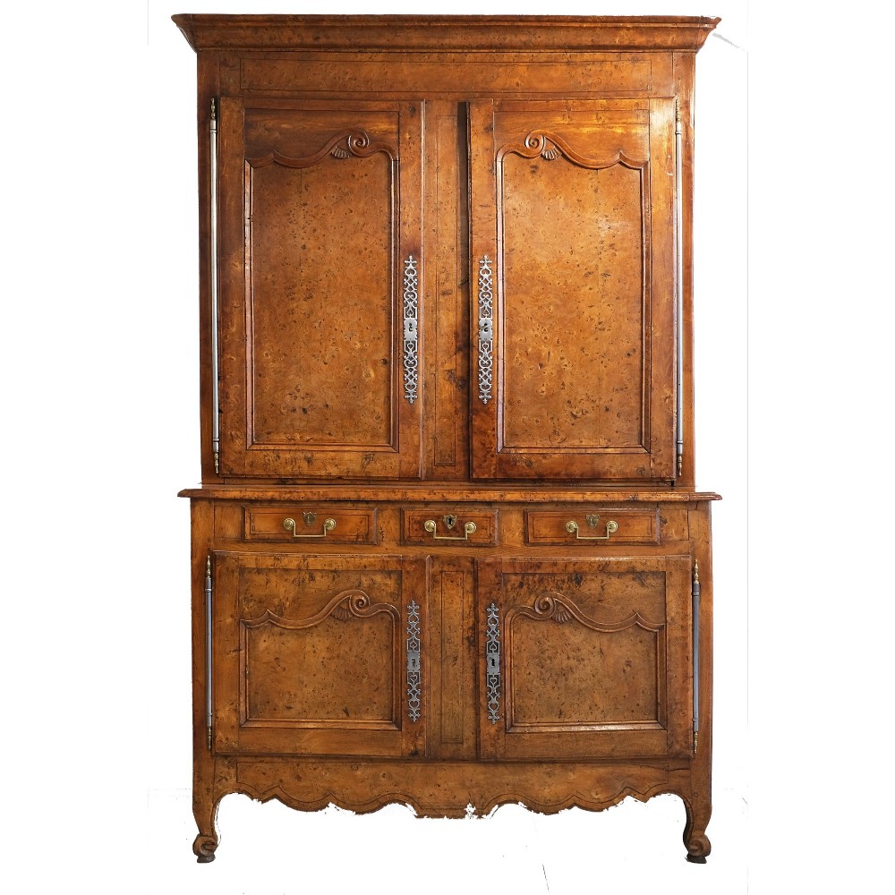 An 18th-century French provincial ash and elm two-part buffet deux corps cabinet featuring carved fielded panels, steel escutcheons, and long barrel hinges.
