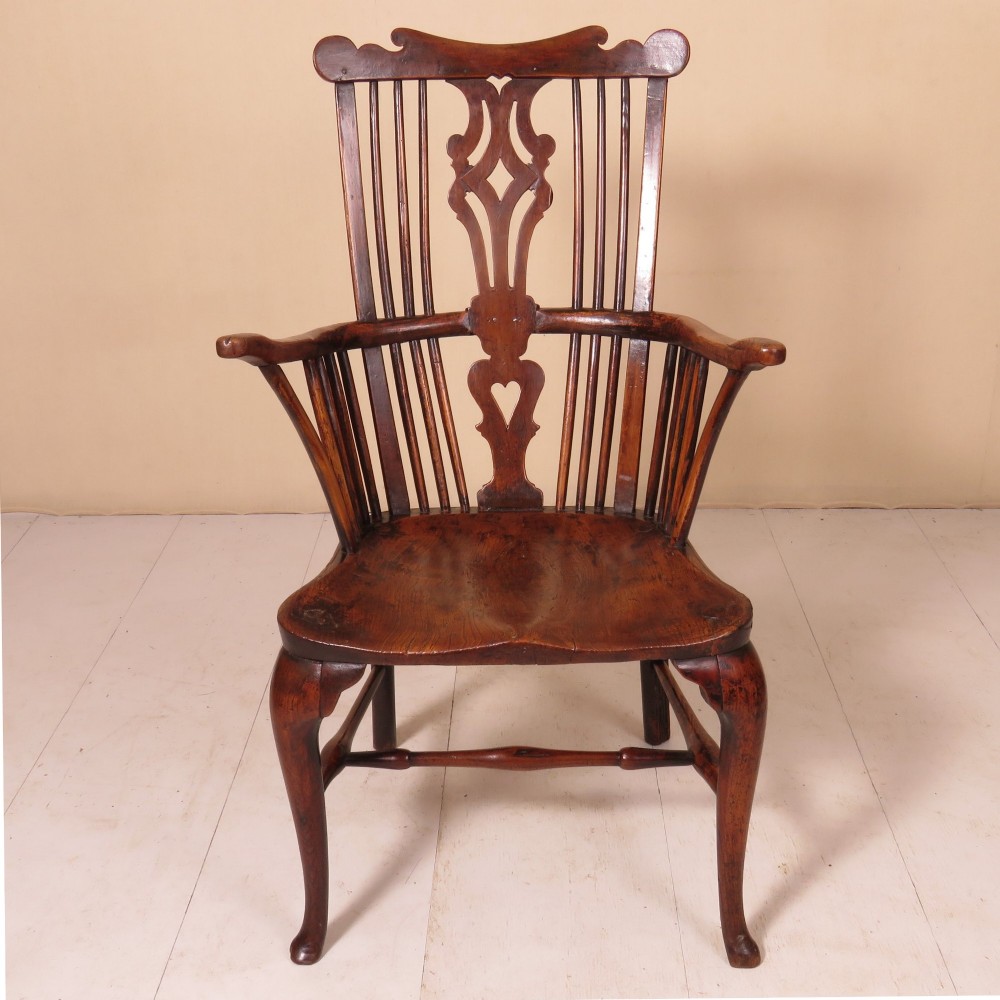 An 18th-century comb-back Windsor armchair in dark finished wood, featuring a pierced central splat, vertical spindles, curved armrests, and cabriole front legs. View III