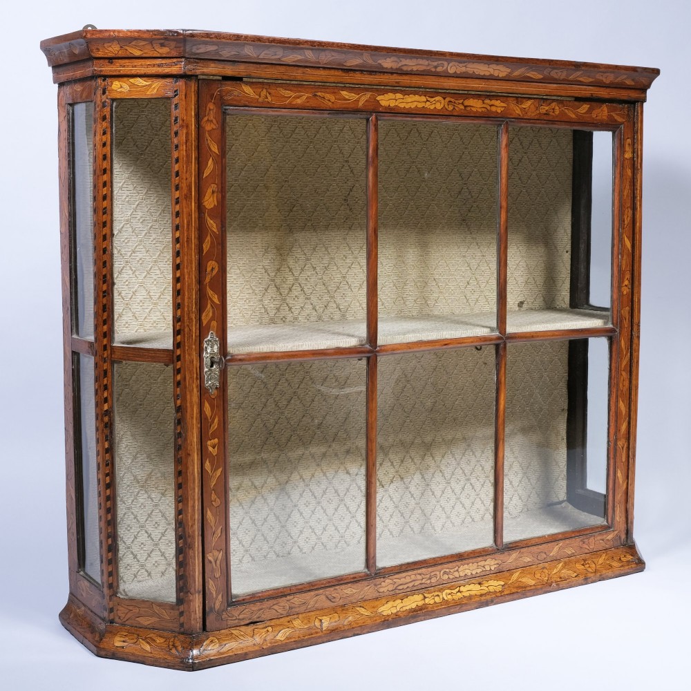 A late 18th-century warm brown wooden wall cabinet featuring floral marquetry inlay, glazed front and side panels, and a fabric-lined interior. View II
