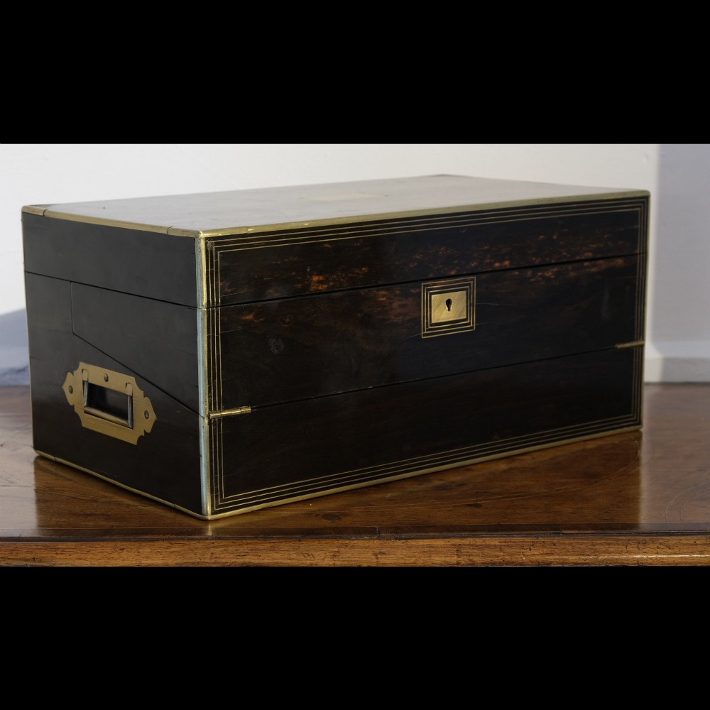 A dark rectangular coromandel wood writing box bound with brass edges, brass stringing inlay, and recessed brass side handles.