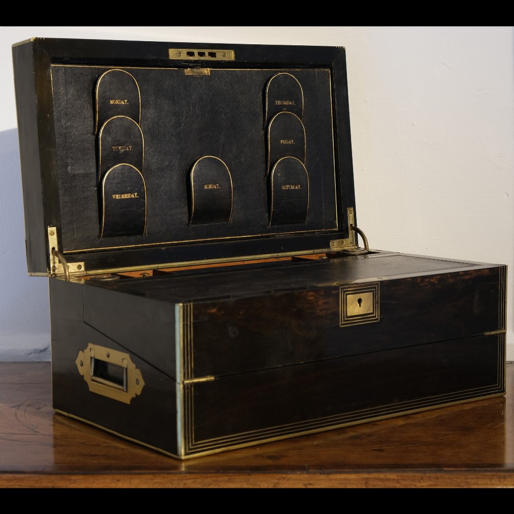 A dark rectangular coromandel wood writing box bound with brass edges, brass stringing inlay, and recessed brass side handles. View II