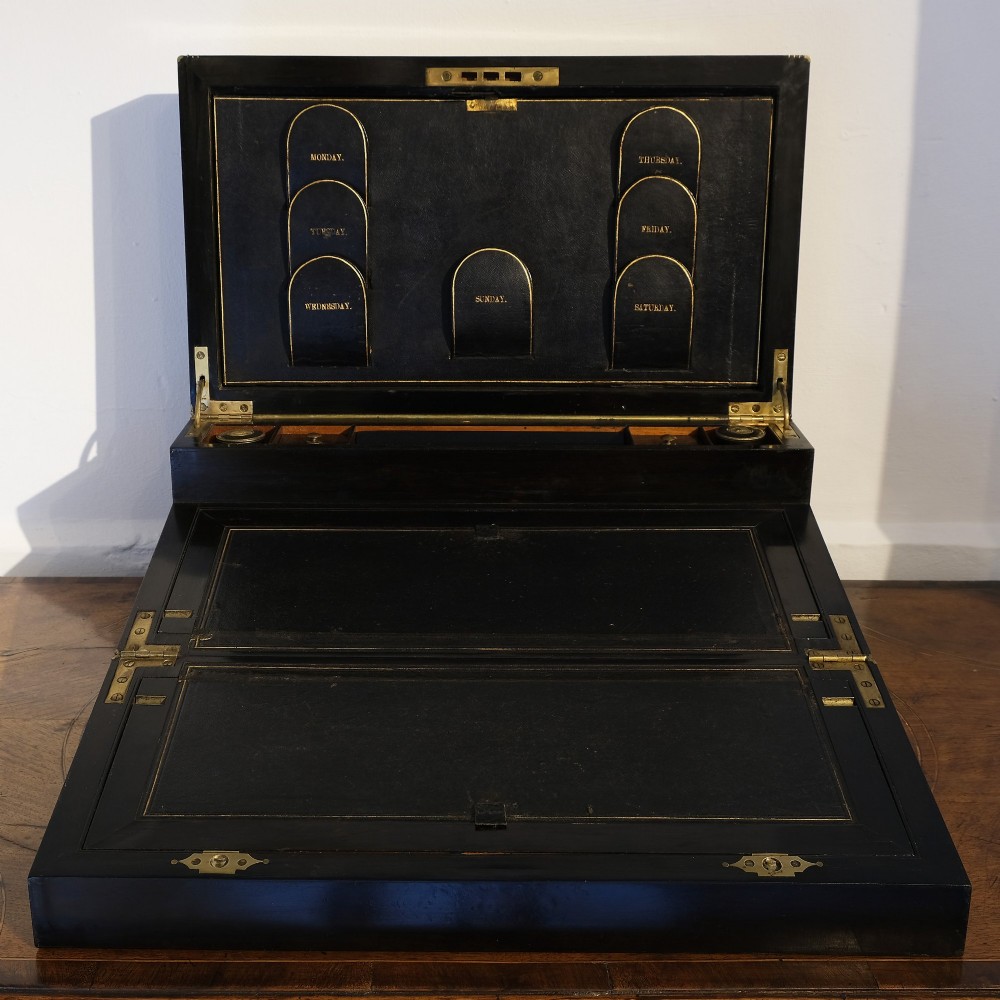 A dark rectangular coromandel wood writing box bound with brass edges, brass stringing inlay, and recessed brass side handles. View IV
