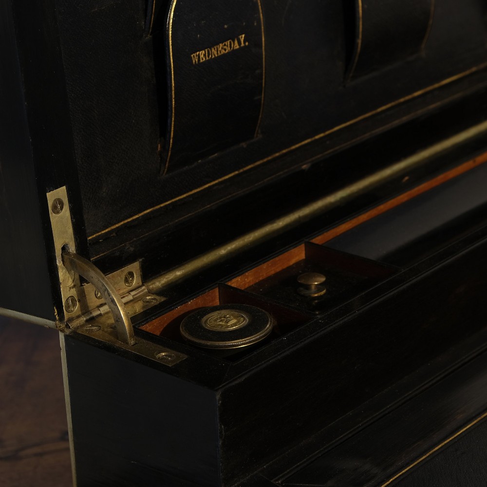 A dark rectangular coromandel wood writing box bound with brass edges, brass stringing inlay, and recessed brass side handles. View V