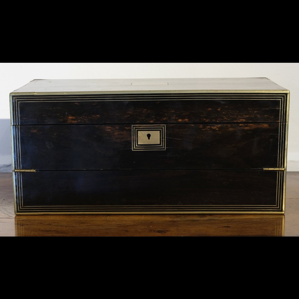 A dark rectangular coromandel wood writing box bound with brass edges, brass stringing inlay, and recessed brass side handles. View VI