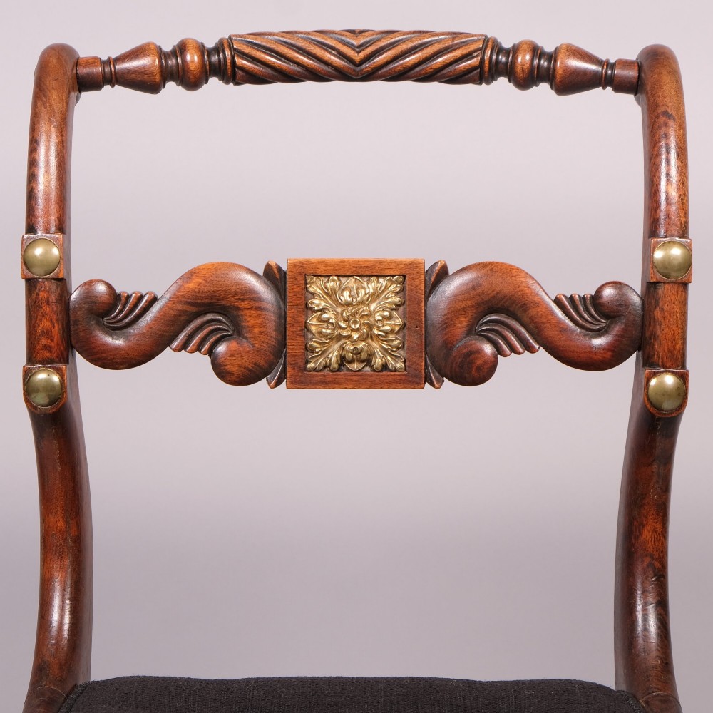 A set of four Regency dining chairs featuring simulated rosewood frames, carved rope twist top rails, brass mounts, and black upholstered seats. View IV