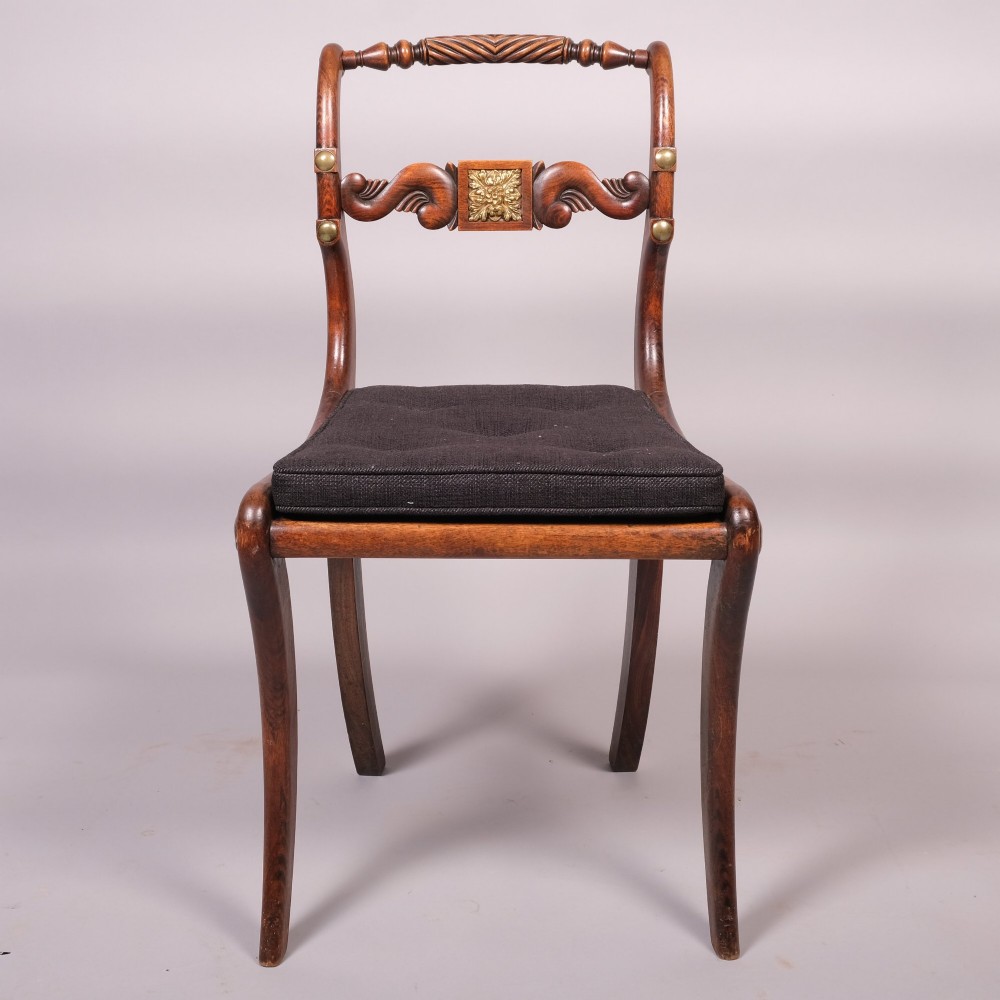 A set of four Regency dining chairs featuring simulated rosewood frames, carved rope twist top rails, brass mounts, and black upholstered seats. View V