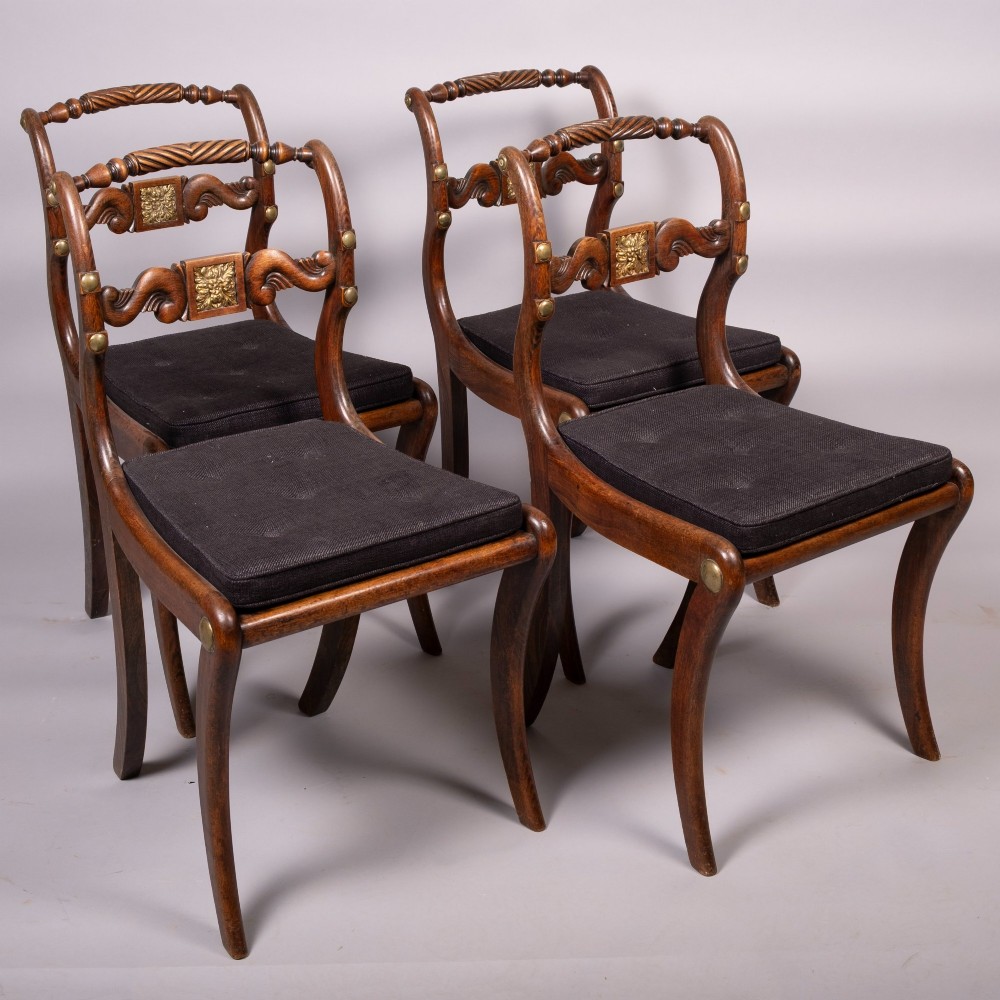 A set of four Regency dining chairs featuring simulated rosewood frames, carved rope twist top rails, brass mounts, and black upholstered seats. View VI