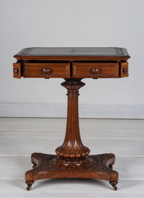 fig 1. A nineteenth-century Regency mahogany reading table with a tooled leather inset top, carved drawer knobs, fluted pedestal column, and carved plinth base on castors.