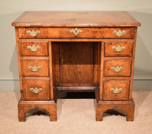 A George I Walnut and Feather Banded Kneehole Desk