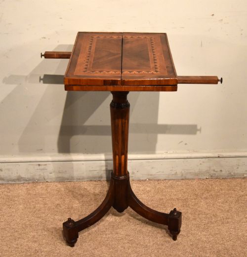 fig 1. A Regency period patience table featuring an olive wood and satinwood inlaid top on a turned pedestal with three splayed legs.